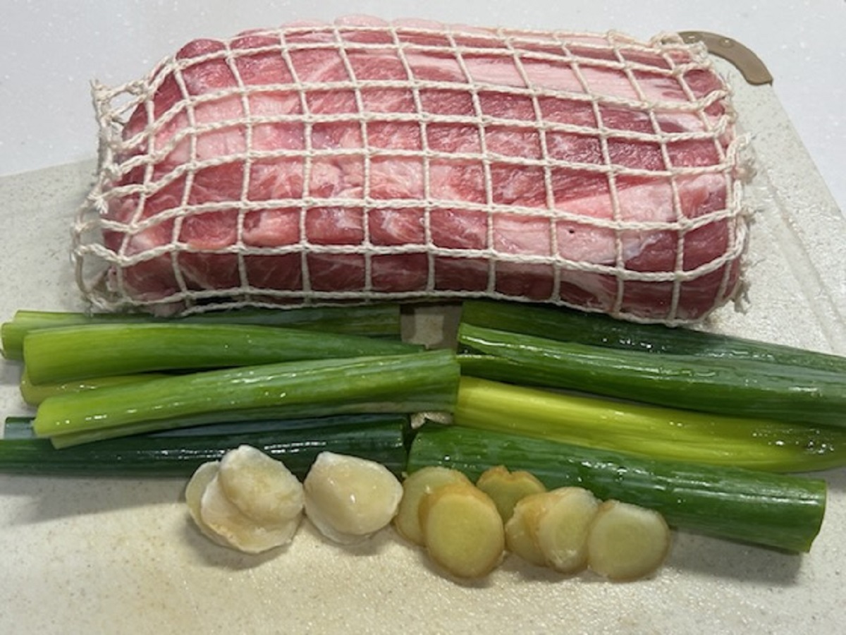 まな板の上に置かれた煮豚の材料 豚肩ロース肉 長ネギ にんにく しょうが